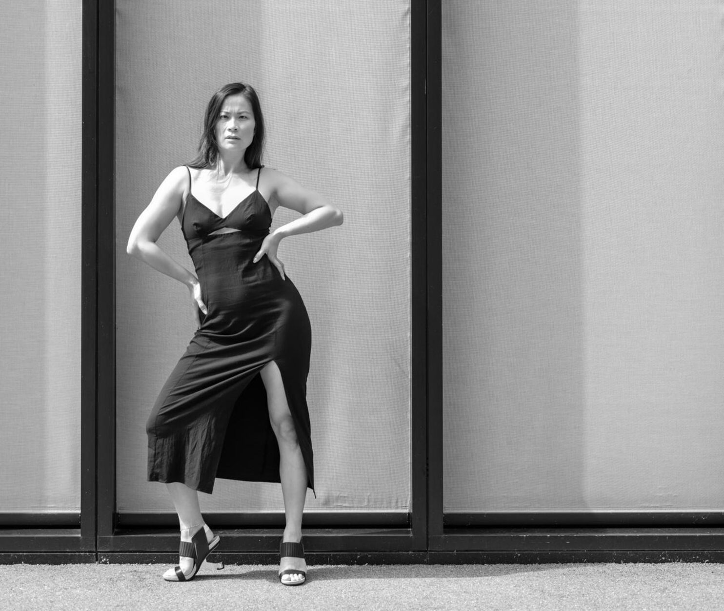 Janet im eleganten Slip-Dress und High Heels, selbstbewusste Pose vor edler Fassade, Schwarz-Weiss